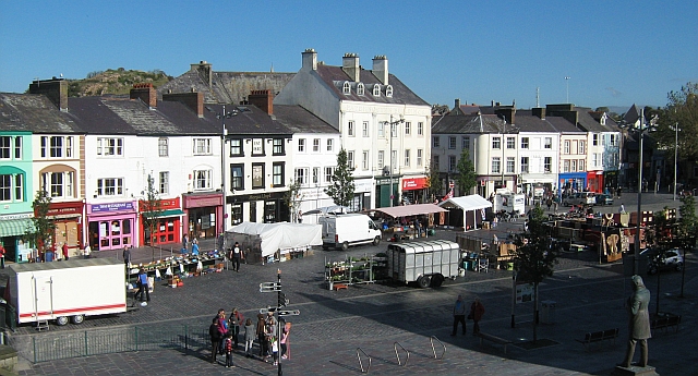 caernarfon town centre - people and stalls on an open square surrounded by lots of small buildings with shops